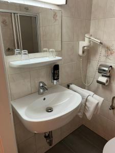 因河畔布劳瑙City Hotel Post 22的浴室设有白色水槽和镜子