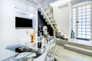卡塔尼亚斯泰西科罗独家公寓式酒店的一间设有玻璃桌和白色椅子的用餐室