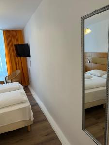 因河畔布劳瑙City Hotel Post 22的配有2张床的酒店客房内的镜子
