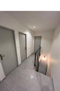 科提尼Propriete de 3 chambres avec terrasse et wifi a Quetigny的空的走廊,有两扇门和楼梯