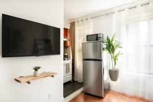 纽约69-4D Trendy Lower East Side 1B BRAND NEW的带冰箱的厨房和墙上的电视