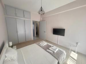 阿特米达AKTIS apartment 3 near airport的白色的客房配有床和电视。