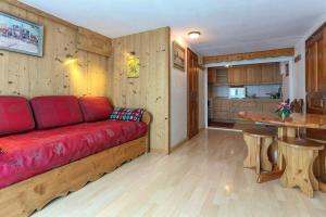 夏蒙尼-勃朗峰Appartement d'une chambre avec jacuzzi et wifi a Chamonix的一间带红色沙发的客厅和一间厨房