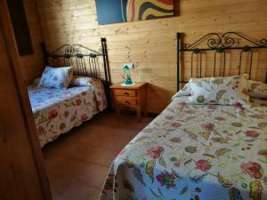 阿达莱斯3 bedrooms chalet with shared pool and wifi at Ardales的一间卧室配有两张床和床头灯。
