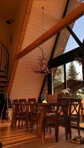 ZhurakyThe Sunset Cabin будиночок з Чаном的甲板上配有桌椅的用餐室