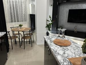 北马马亚-讷沃达里New Eva Unique Luxury Apartament的厨房配有带桌椅的柜台