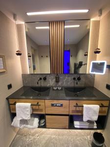 伊施格尔蒂罗尔酒店的一间带两个盥洗盆和大镜子的浴室