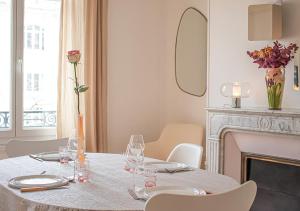 兰斯Rare! Magnifique appartement - Vue Cathédrale的用餐室配有玻璃桌和壁炉