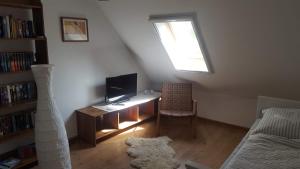 埃姆登Haus Nordsee的客厅配有书桌、电视和窗户