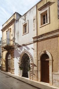 图里ALBERGO DIFFUSO ROSSI DIMORA Di CHARME的街道上两扇拱门的古老建筑