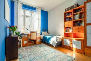 克拉科夫Botaniczny Pokój的一间卧室设有蓝色的墙壁、一张床和一张书桌