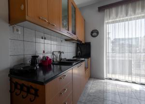 拉里萨Special Apartment的厨房配有木制橱柜和黑色台面
