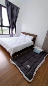 普崇16 Sierra Puchong Zentro 5 人 Supreme二房公寓的卧室地板上的一张带黑色毯子的床