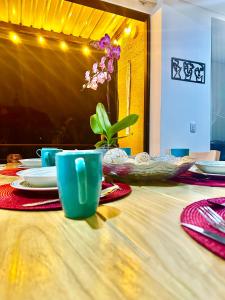 亚美尼亚Apartamento Campestre 5 Minutos del Aeropuerto y 20 minutos del parque del Cafe Ubicado en la Tebaida G305.1的一张桌子,上面有蓝色的杯子和盘子,上面有植物