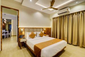 孟买Home2 Suites and Service Apartments, Mumbai Airport的一间带大床的卧室和一间餐厅