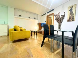 萨拉戈萨Apartamentos Dos Torres Gandalf - Excelente ubicación centrica con garaje incluido的客厅设有餐桌和黄色沙发
