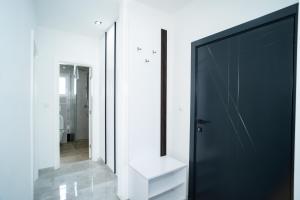 拉克塔希Apartmani Mila的浴室设有黑色的门和镜子