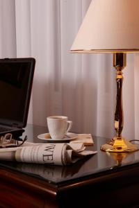 杜塞尔多夫Hotel Villa Achenbach的一张带笔记本电脑的桌子和一盏杯子及一盏灯