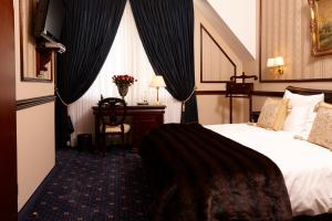 杜塞尔多夫Hotel Villa Achenbach的配有一张床和一张书桌的酒店客房