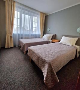 利耶帕亚Hotel Linda - Helvita的酒店客房设有两张床和窗户。