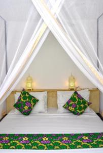 江比阿Daima Villas的帐篷内的白色床和2个枕头