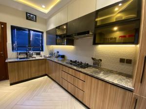 拉瓦尔品第Firefly Retreat-your home away from home的一个带木制橱柜和窗户的大厨房