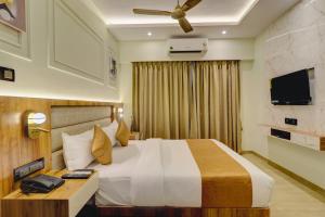 孟买Home2 Studio Apartments的配有一张床和一台平面电视的酒店客房
