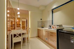 孟买Home2 Studio Apartments的一间带桌子的厨房和一间餐厅