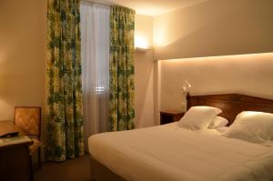 克卢尼勃艮第酒店的一间卧室配有床和带窗帘的窗户