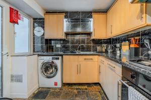 布里斯托Chic Victorian Basement Flat的厨房配有洗衣机和洗衣机。