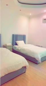 利雅德Alwaha-Appartement的一间客房内配有两张床的房间