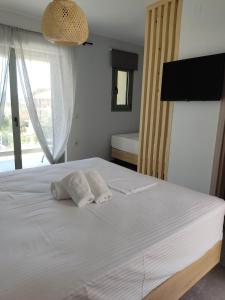 奈德里Olivar del Mar的卧室配有白色床和2条毛巾