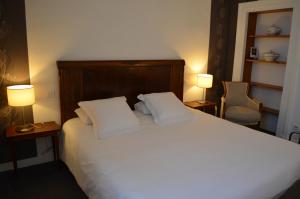 克卢尼勃艮第酒店的一间卧室配有一张带两个枕头和两个灯的床。