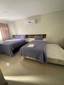 克拉图Flats Grangeiro的一间卧室配有两张紫色床单