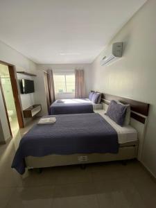 克拉图Flats Grangeiro的酒店客房设有两张床和电视。
