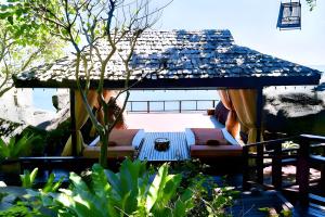 茶云莱海滩Baan Hin Sai Resort & Spa的天井配有遮阳伞和沙发。