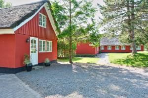 布拉万德Hygge Ho - mitten in der Natur mit Sauna und Spa的前面有树木的红房子