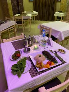 赫尔格达Golden Sun Hotel - Hurghada的紫色桌布上带食物盘的桌子