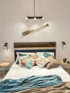 蒙塔莱格罗Eraclea Minoa Village的一张带两个枕头的床和墙上的棒球棒