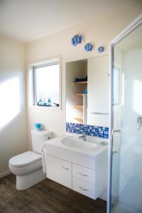 怀蒂昂格水星湾假日公园酒店的一间带卫生间、水槽和窗户的浴室