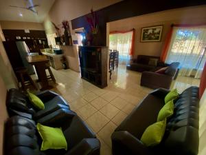 CartagenaCasa Pochotal的客厅配有两张黑色真皮沙发和绿色枕头