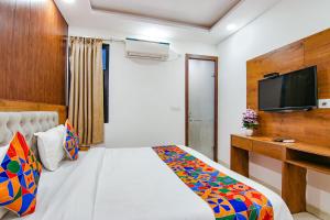 新德里Hotel Belwod INN Near Delhi International Airport的一间卧室配有一张床和一台平面电视