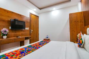 新德里Hotel Belwod INN Near Delhi International Airport的一间卧室配有一张带彩色毯子的床