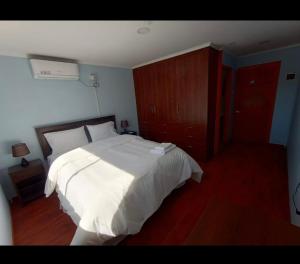 SalamancaHotel Santa Emilia Salamanca的卧室配有白色的床,铺有木地板