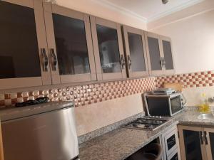 梅克内斯Charmant appartement à louer à meknès的厨房配有冰箱和微波炉。