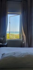 开普敦Beachfront 3-bedroom with Robben Island views的一间卧室设有海景窗户