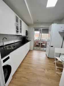 马德里Habitación en Madrid的白色的厨房配有水槽和洗碗机