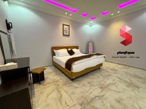 塔伊夫منتجع سمو الوسام Wesam Highness Resort的卧室配有一张床,墙上有标志