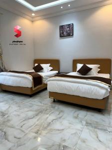 塔伊夫منتجع سمو الوسام Wesam Highness Resort的配有两张床铺的酒店客房,铺有大理石地板