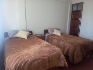 波托西HOTEL NOBLEZA的一间客房配有两张床和一张沙发